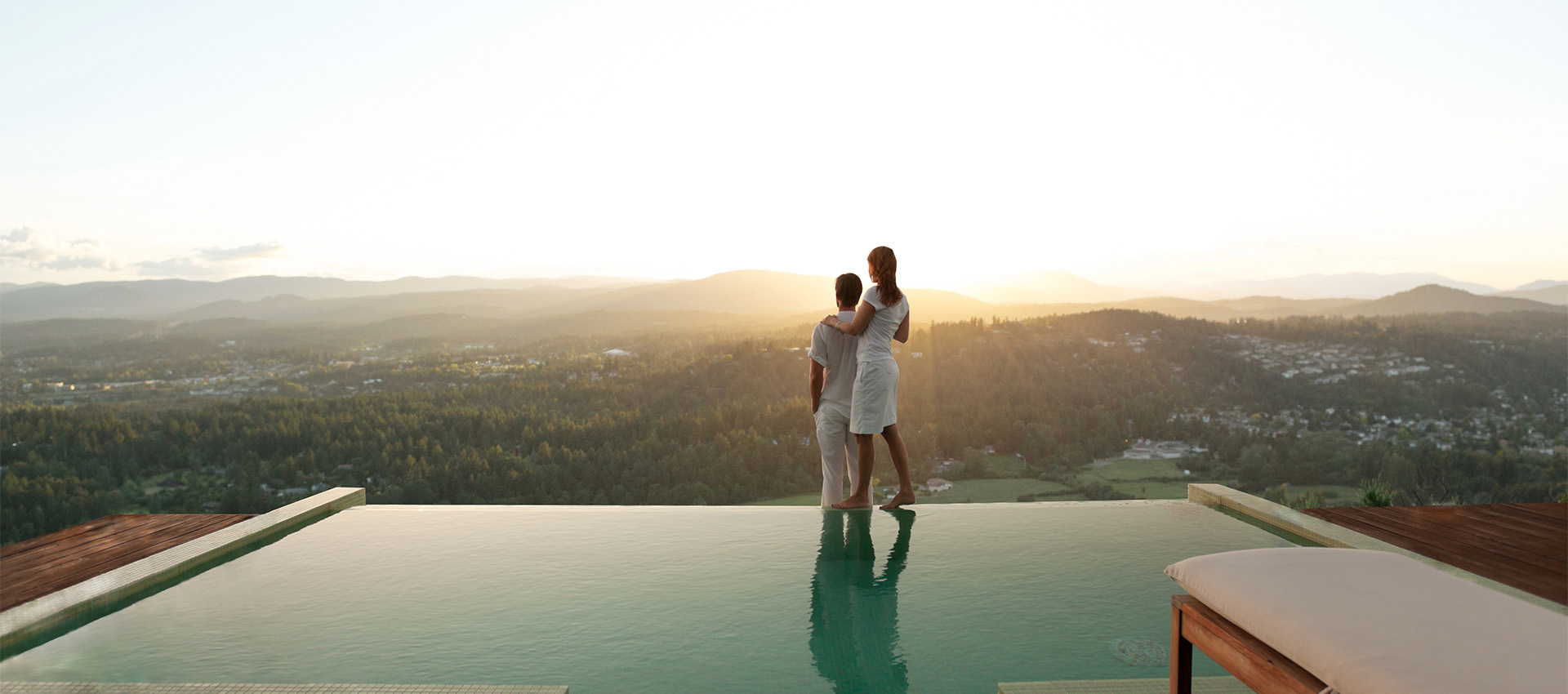 A couple standing on the edge of a pool looking out into the distance image