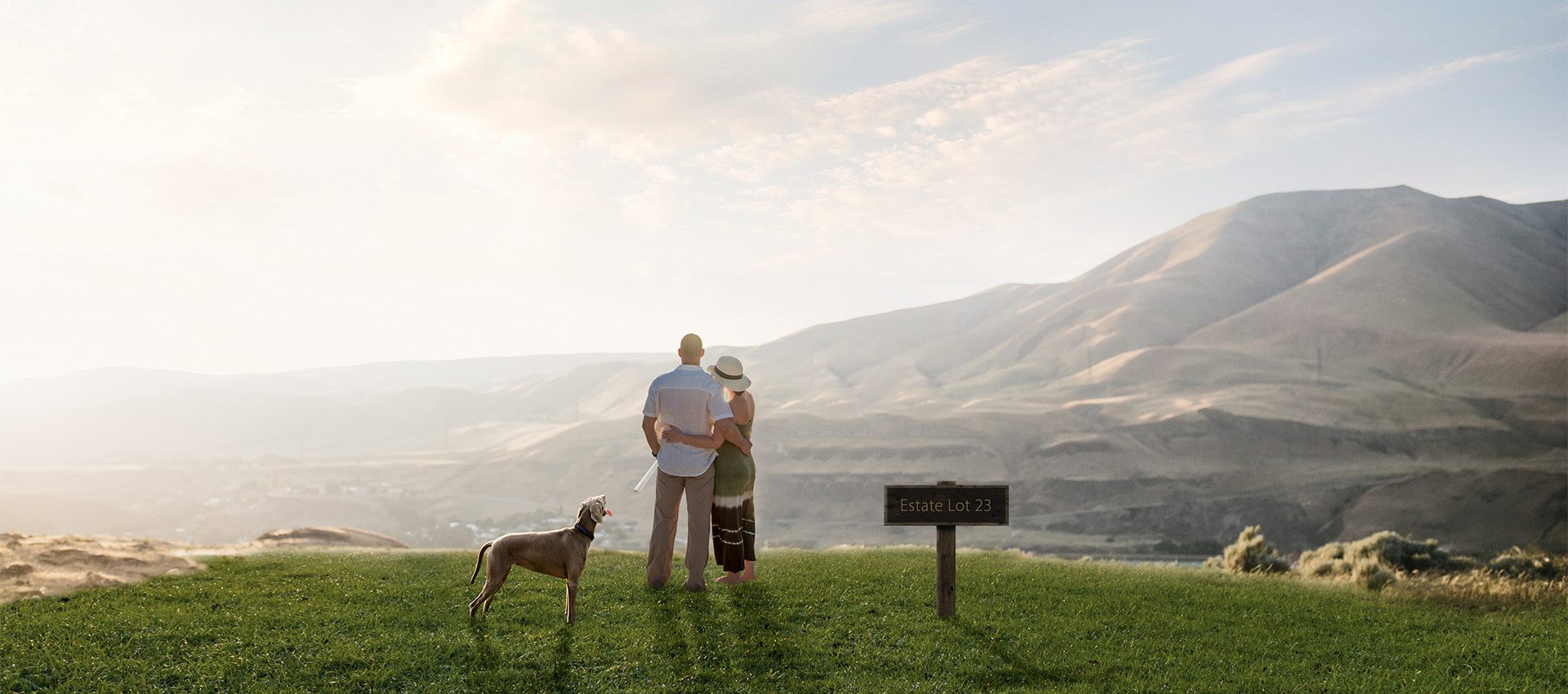 Image of a couple and dog standing overlooking the mountains