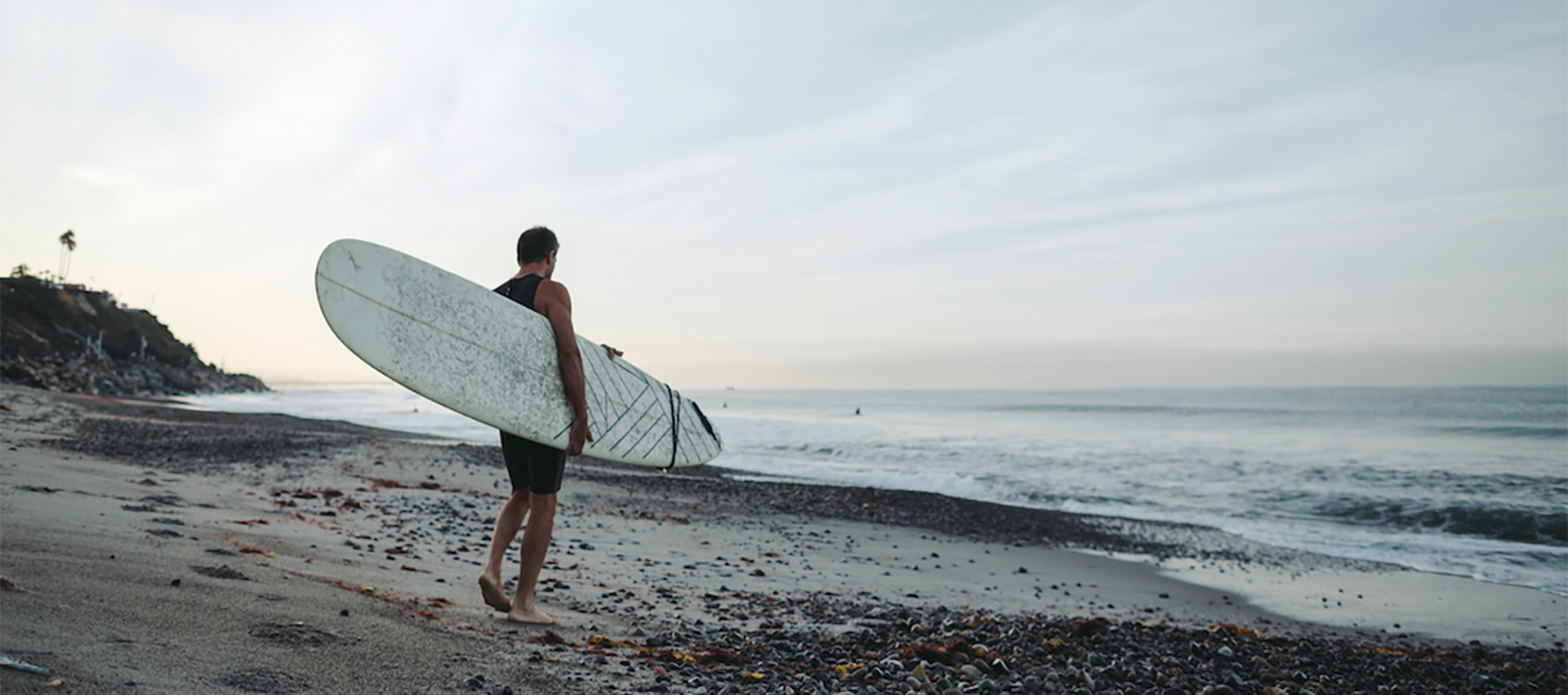 Image of a surfer standing on the beach