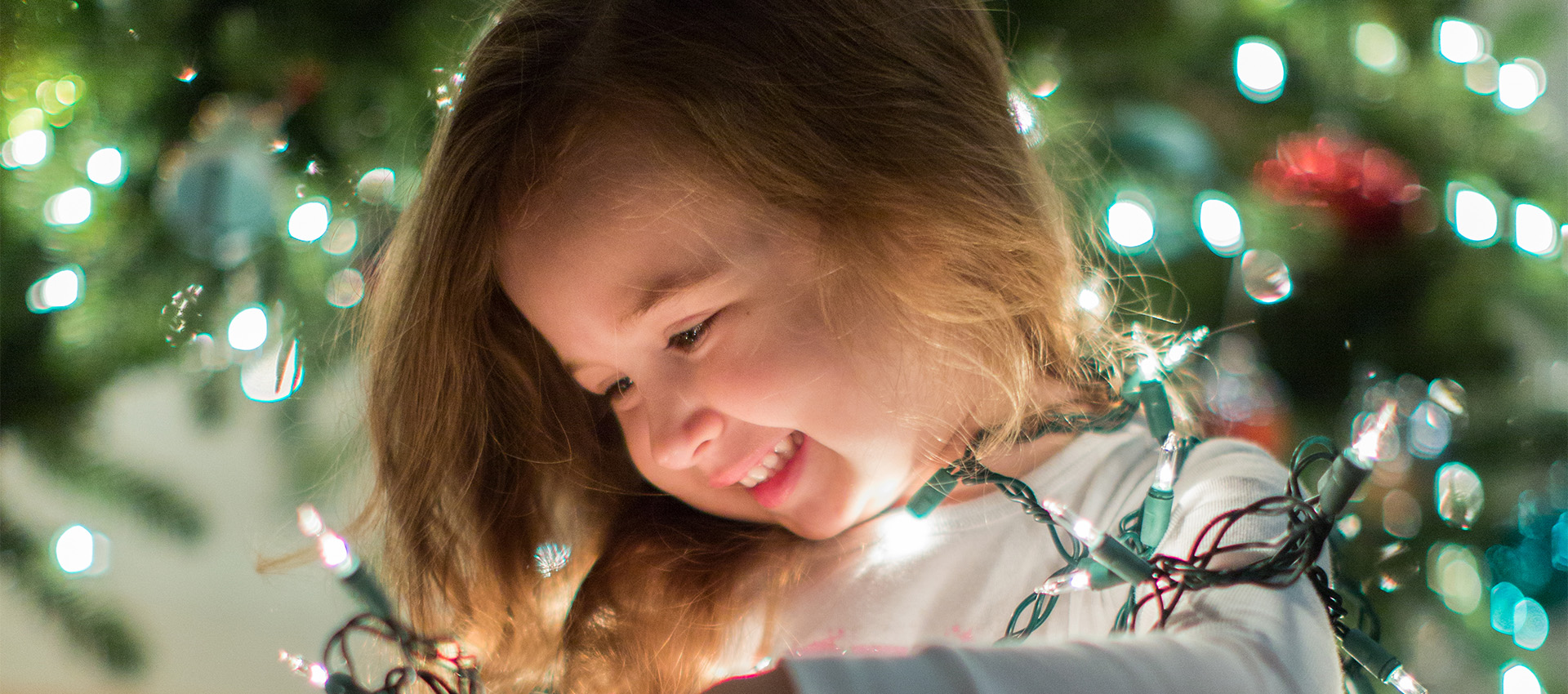 Image of a little girl in front of the Christmas tree