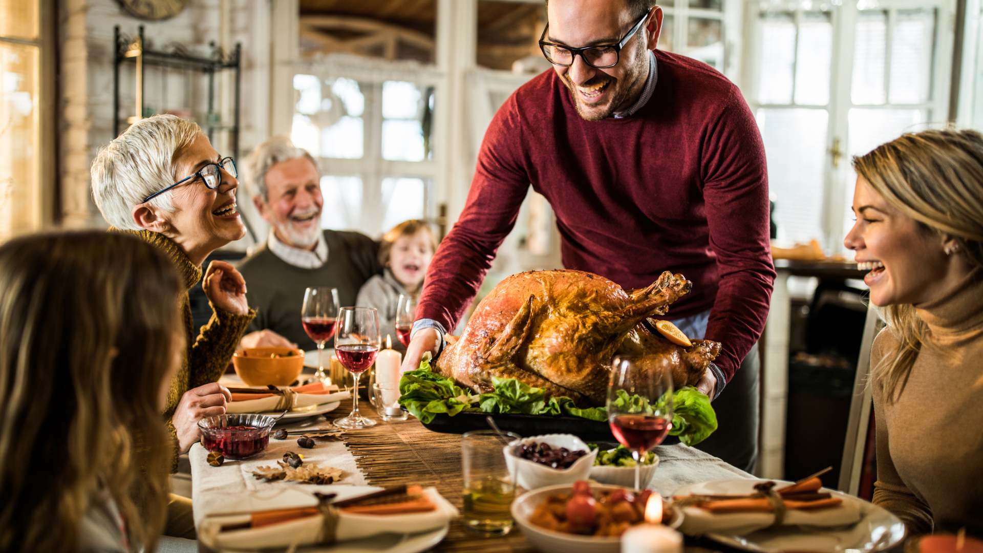 Image of a family sitting down to Thanksgiving dinnner